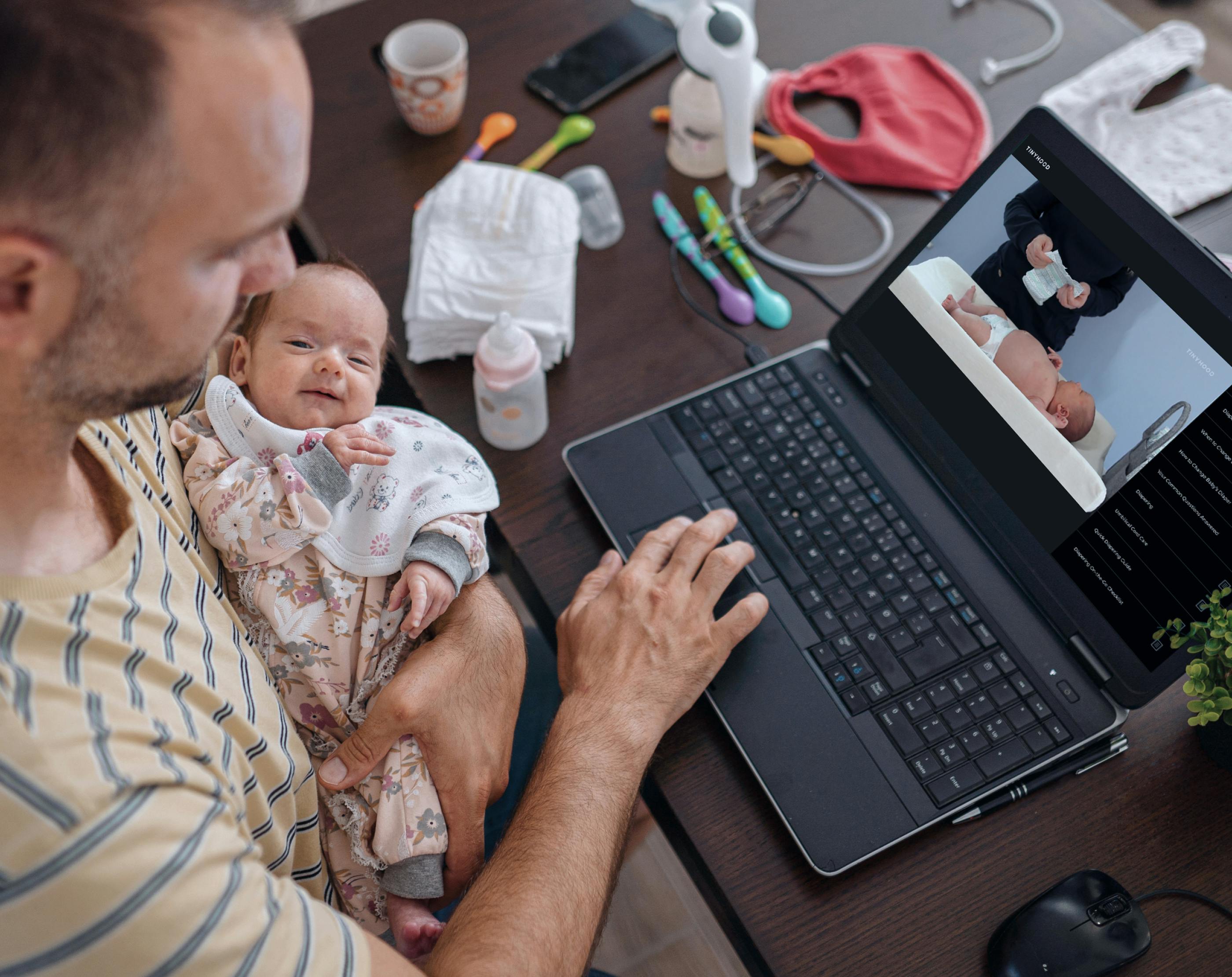 Background. Woman holding baby and watching video on tablet.