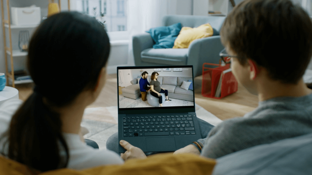 Parents watching a Tinyhood video on their laptop.